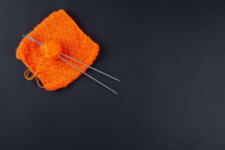knitting ball of yarn and knitting needles on a black background