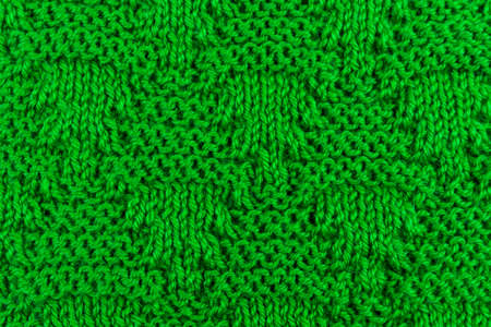 Knitted surface of woolen things as a background. Close-up of soft fabric green color knitted patterns texture. Warm winter clothing. Background textile surface with copy space for text.の写真素材