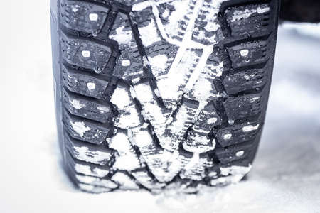 winter tires with spikes on snow, transport road northern wheels, climate winter seasonの写真素材