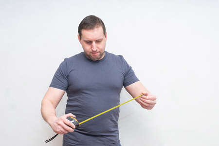 Cropped male using yellow Tape measure copy spaceの写真素材