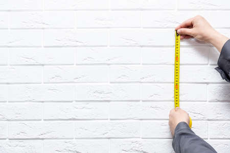 Cropped male using yellow Tape measure copy spaceの写真素材