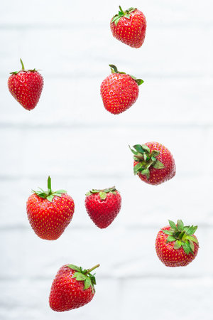 Falling strawberry isolated on white background, selective focusの写真素材