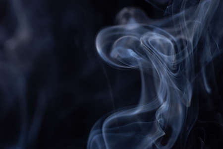 Abstract white smoke moves on black background. Beautiful swirling gray smoke.の写真素材