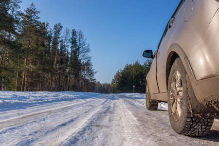 The headlights of a car. Close-up of the rear light of a car on a winter road.の写真素材