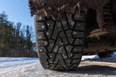 winter tires with spikes on the snow / transport road northern wheels, climate winter season
