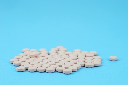 Top view of white pills on blue surfaceの写真素材