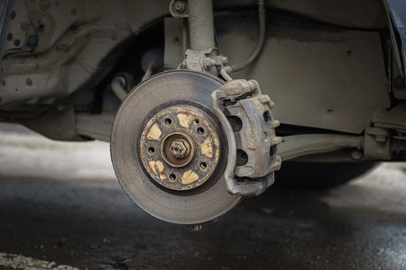 Old and rusty car's suspension parts. Rusted disc brake and caliper on the car. Automotive industry and garage concepts. selective focusの写真素材