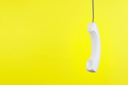 White phone handset with soft shadow on yellowの写真素材