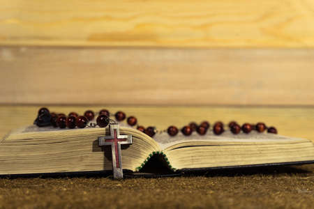 Bible and the crucifix on a gold table. Beautiful new wood background. Religion conceptの写真素材