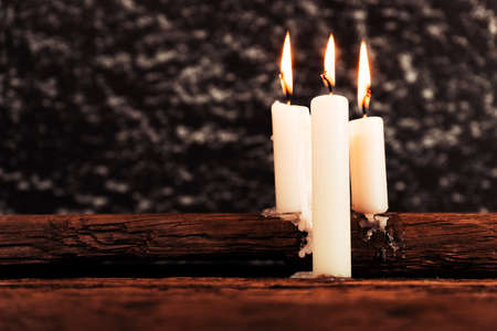 Candle on a old oak wooden table. Beautiful gold background.Religion concept.の写真素材