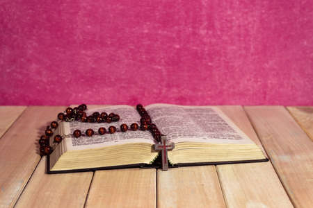Bible on a new wooden table. Beautiful pink background.Religion concept.の写真素材