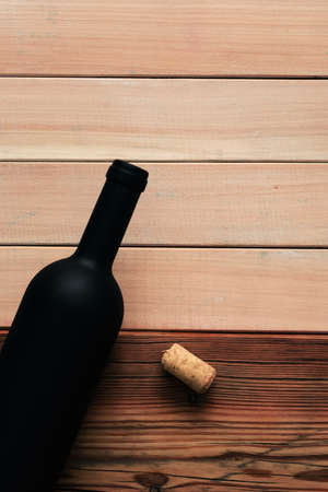 Black bottle of red wine on a wooden table. Beautiful new wooden backgroundの写真素材