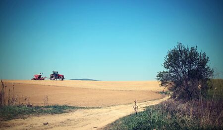 Tractor plowing in spring field.の写真素材