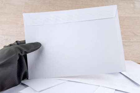 man with protective gloves examines anonymous envelopesの写真素材