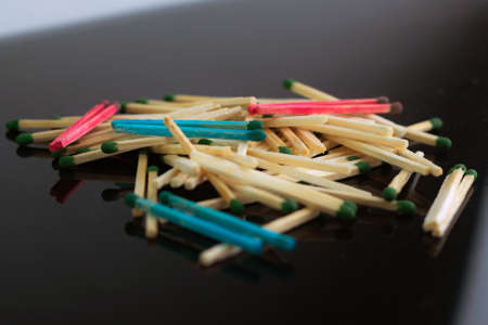 homosexuality concept: several pairs of blue and pink matches in front of a pile of ordinary matches, black background, short focus, limited lighting, toningの写真素材