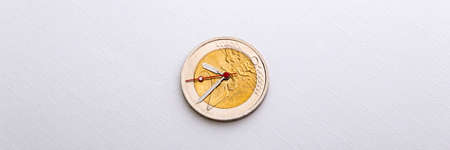 financial analysis: 2 euro coin with hour hands on a white background, short focus, closeの写真素材