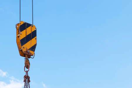 building construction: crane hook, chain and cables against the blue skyの写真素材
