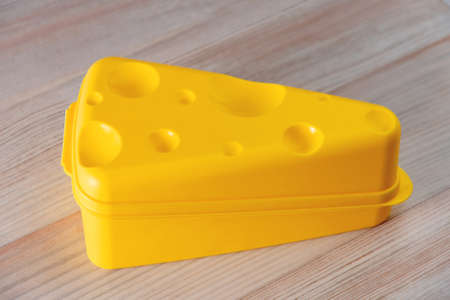 eco-friendly yellow special container for storing cheese, on a wooden table, short focusの写真素材