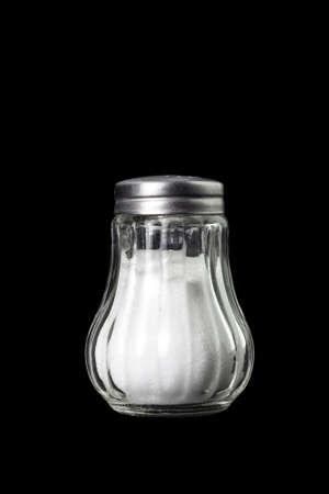 glass salt shaker with metal cap isolated on black backgroundの写真素材