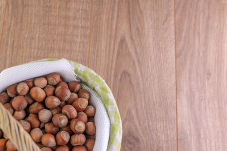 hazelnuts: many nuts lie in a basket on a wooden background
