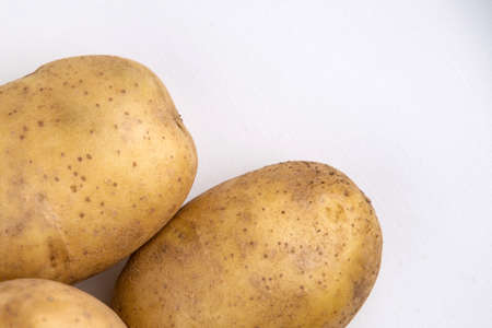 vegan diet: fresh raw organic potatoes, on white, short focus