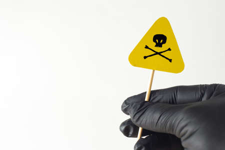 mortal danger sign in man's hand with black glove, on whiteの写真素材