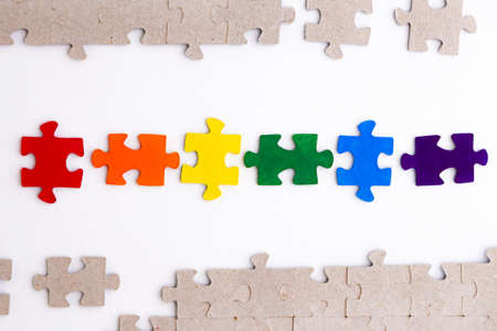 LGBT pride flag, built from a puzzle, among gray puzzles, short focus, on a white background, top viewの写真素材