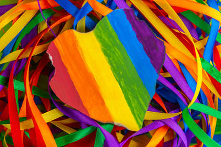 Concept - oppression of freedom of the LGBT community: a burned and torn rainbow heart lies on a...