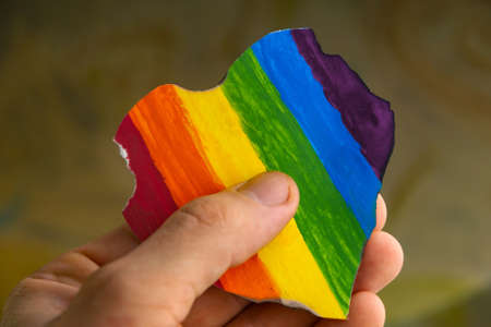 Concept - harassment of the freedom of the LGBT community: burned and torn rainbow heart in a...
