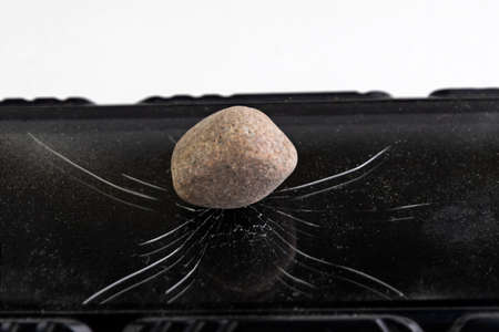 glass phone covered with concentric cracks, on the glass is a whole hazelnut, short focus, toning