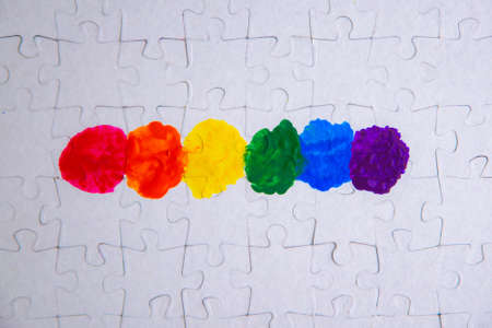 Place of LGBT people in the public structure: puzzle with the coloring of the rainbow flag against a...