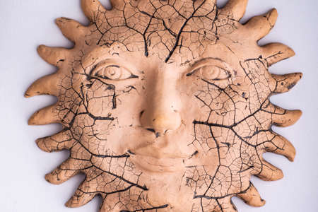travel artifacts: antique ceramic sun with prominences, on a light background, short focusの写真素材