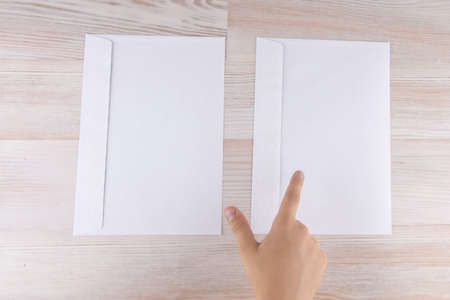 the boy makes a choice of two envelopes, pointing his finger at the right, reduced contrast
の写真素材