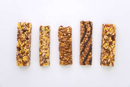 vegan dessert: several cereal bars with raisins and honey, isolated on white, short focus