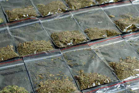 crime evidence: many packaged doses of cannabis lie in rows on a dark surfaceの写真素材