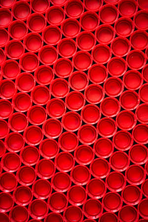 recycling plastic concept. red abstract background of plastic caps from a bottle, top view, short focusの写真素材
