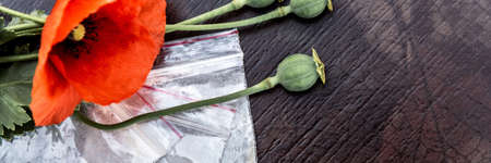 flowers and opium poppy heads next to packages of heroin, soft focus, toningの写真素材