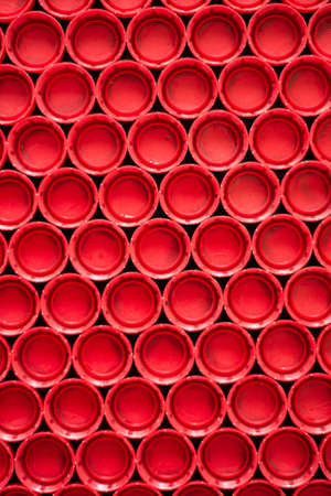 recycling plastic concept. red abstract background of plastic caps from a bottle, top view, short focusの写真素材