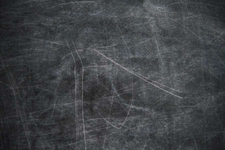 back to school: black chalkboard with blurry traces of white chalk and crayons, minor scratchesの写真素材