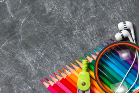 multicolored school supplies lie on black chalkboard, short focus, partial blurの写真素材