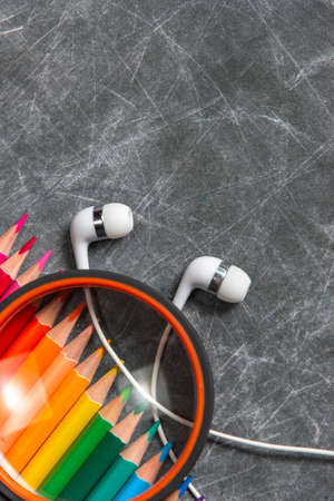 multicolored school supplies lie on black chalkboard, short focus, partial blur