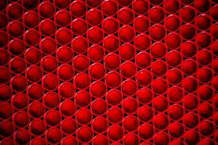 recycling plastic concept. red abstract background of plastic caps from a bottle, top view, short focusの写真素材