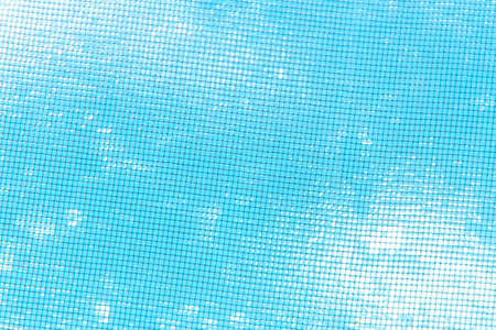 blurred blue sky with clouds visible through metal fine mesh