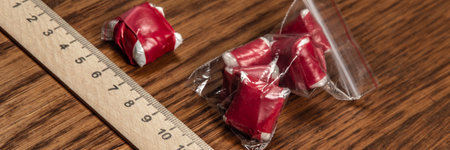 evidence of smuggling traffic: packaging of an unknown drug next to the forensic scaleの写真素材