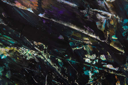 colorful creative motley background: smudged residues of oil paints on a wooden palette, short...