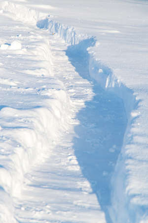 winter emergency: deep trench-trail in the snow, dug for the passage of people after heavy snowfallの写真素材