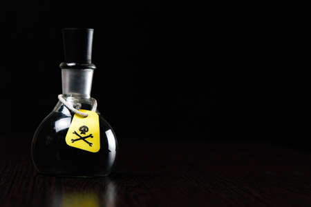 vial of poison with a hazard warning label, on a dark background, toning, short focusの写真素材