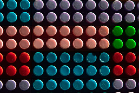 childish game background: darkened plane of plastic multi-colored bricks, blur, selective focus