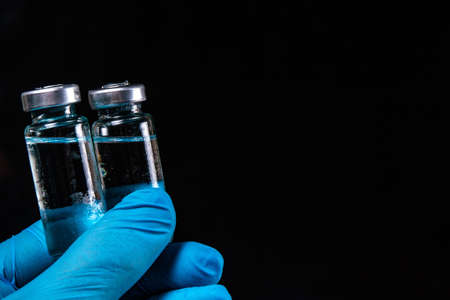 2 doses of Sars-Kov-2 coronavirus vaccine in transparent glass ampoules, covered with frost, on a...