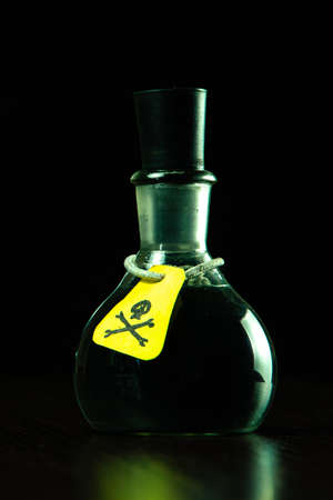 vial of poison with a hazard warning label, on a dark background, toning, short focusの写真素材